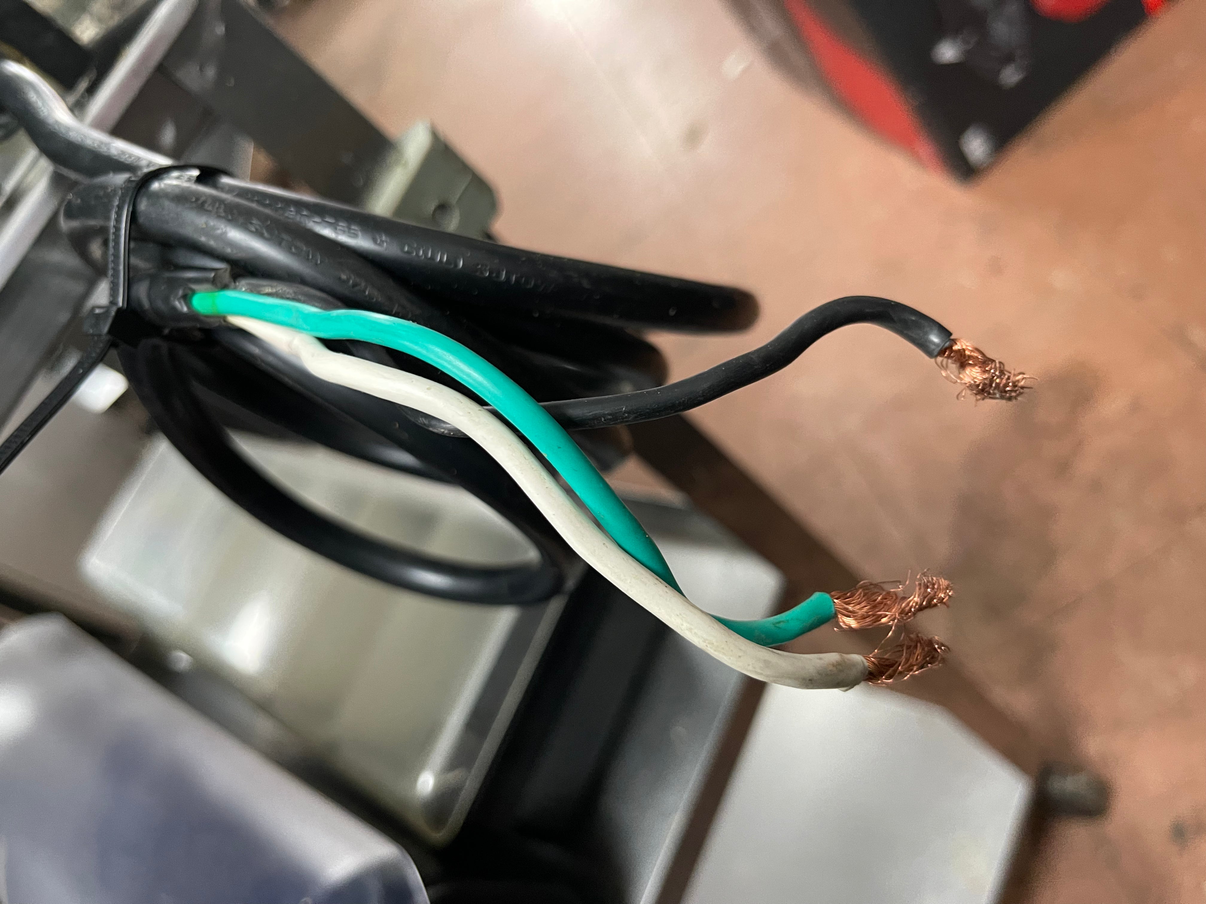 Electric cord for hard wiring a used Spring USA MAX Induction Cook and Hold Titanium Induction Range with visible scuffs and scratches, featuring a stainless steel body and a glass cooktop.