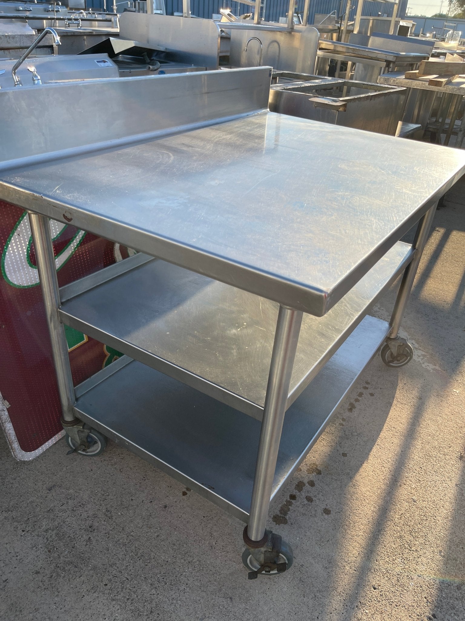 Used 48"x32" Heavy Stainless Table with Shelves, Casters and 6" Backsplash JD - SS324 - Falcon Restaurant Supply - 3