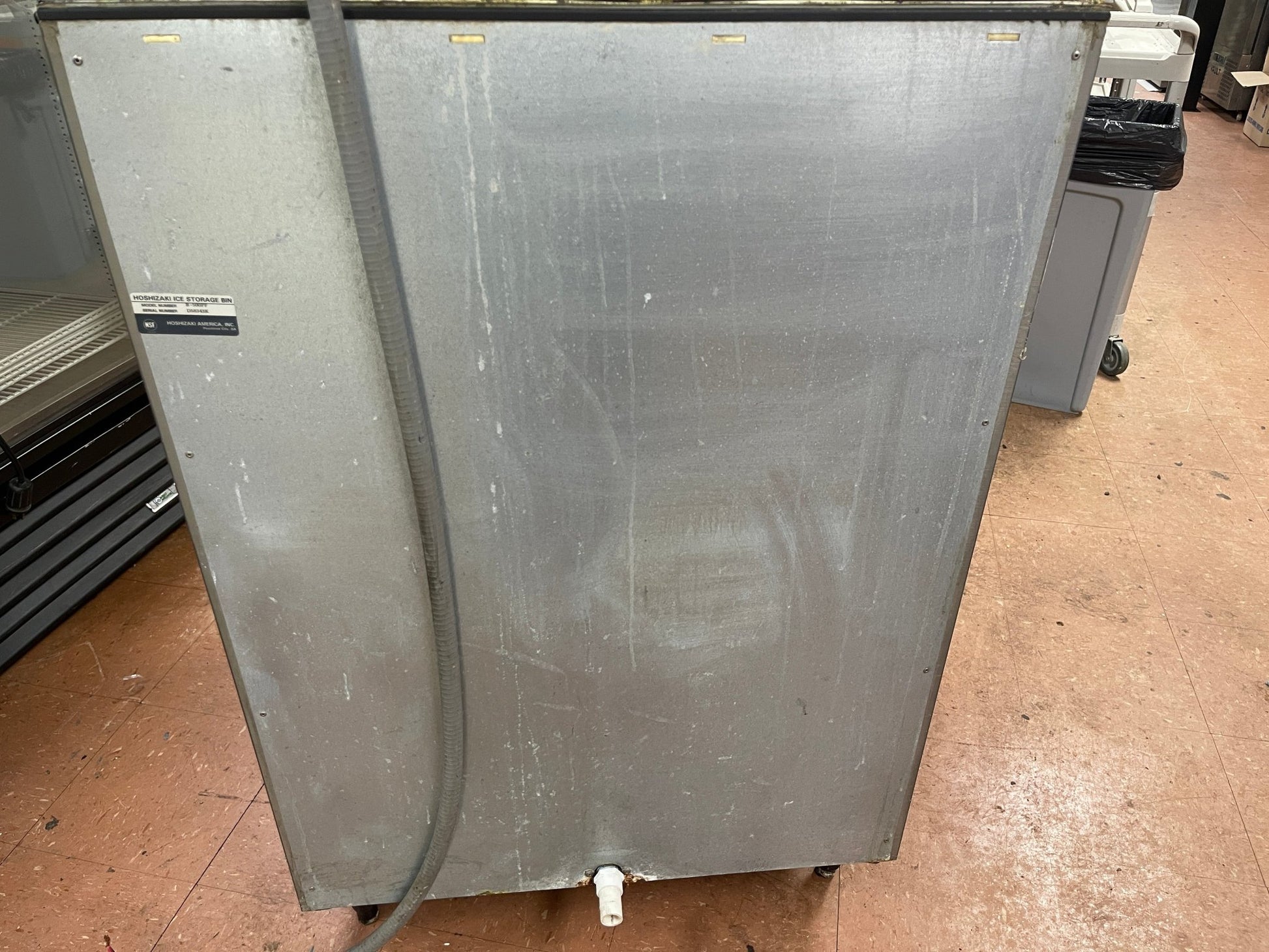 Stainless metal back panel of ice maker storage bin