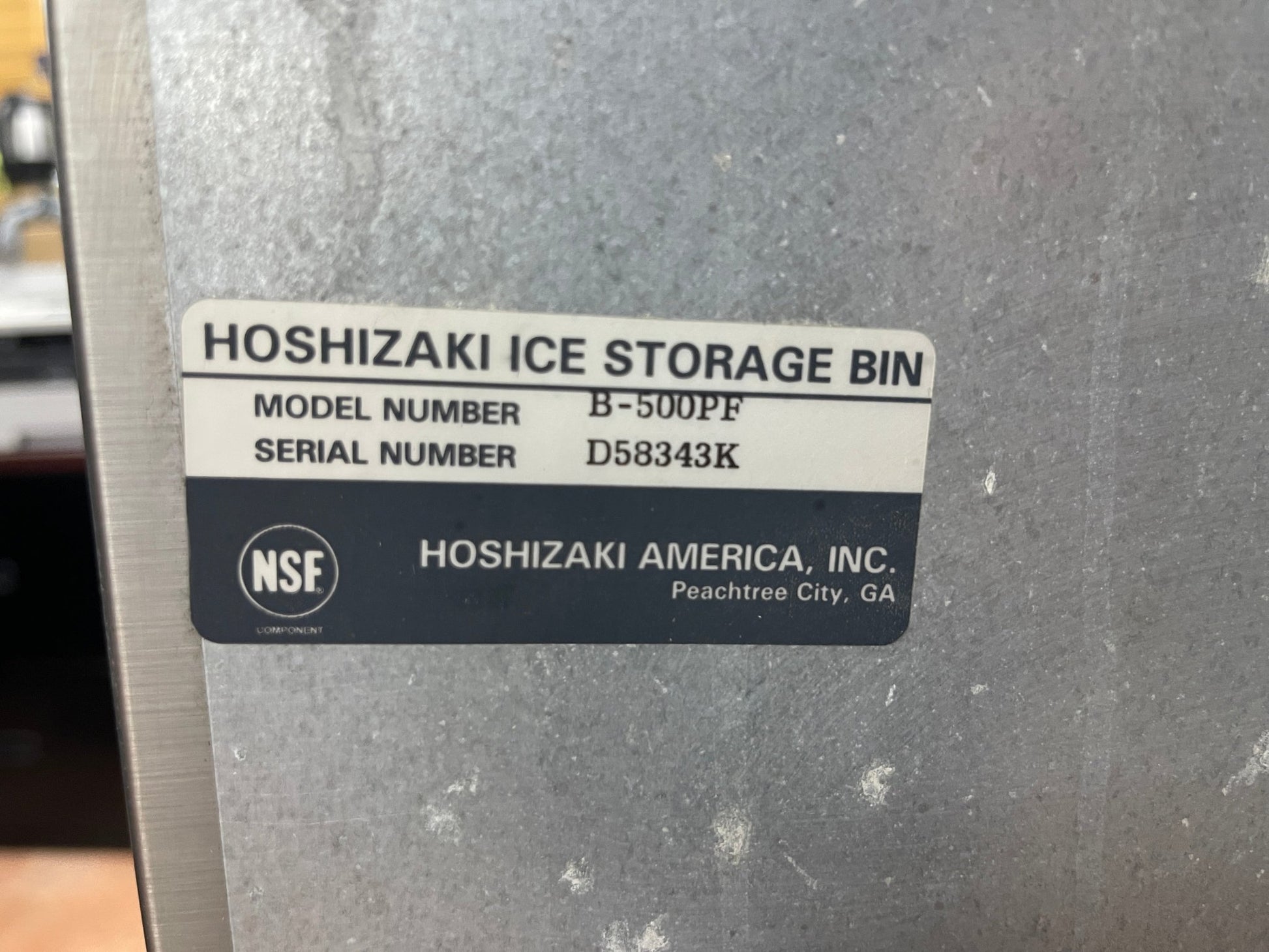 Hoshizaki ice storage bin with a label on a metallic surface