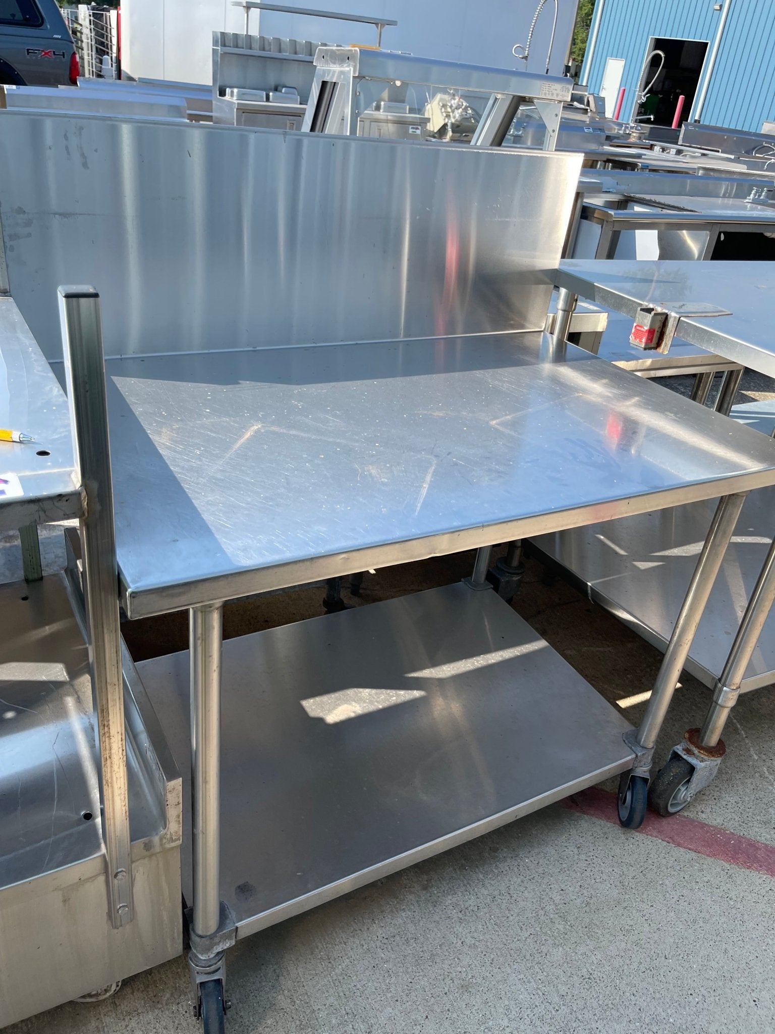 Used 48" Stainless Steel Table with a 16" Backsplash and Caster Wheels - SS114 - Falcon Restaurant Supply - 1